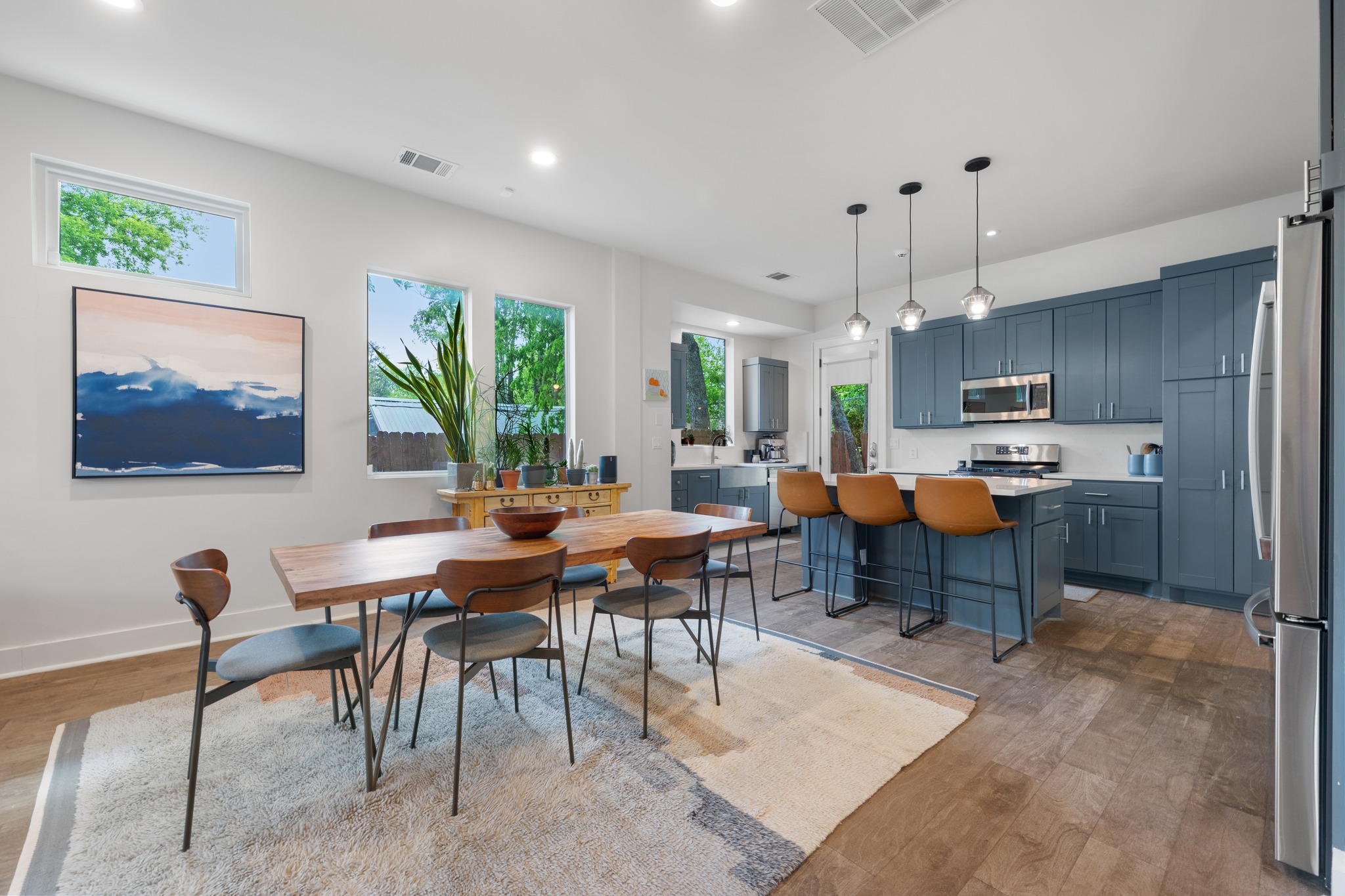 4904 Duval Street, Unit A Austin, TX 78751 - Photo 11 of 39 a open dining room with stainless steel appliances kitchen island granite countertop a table chairs and a living room