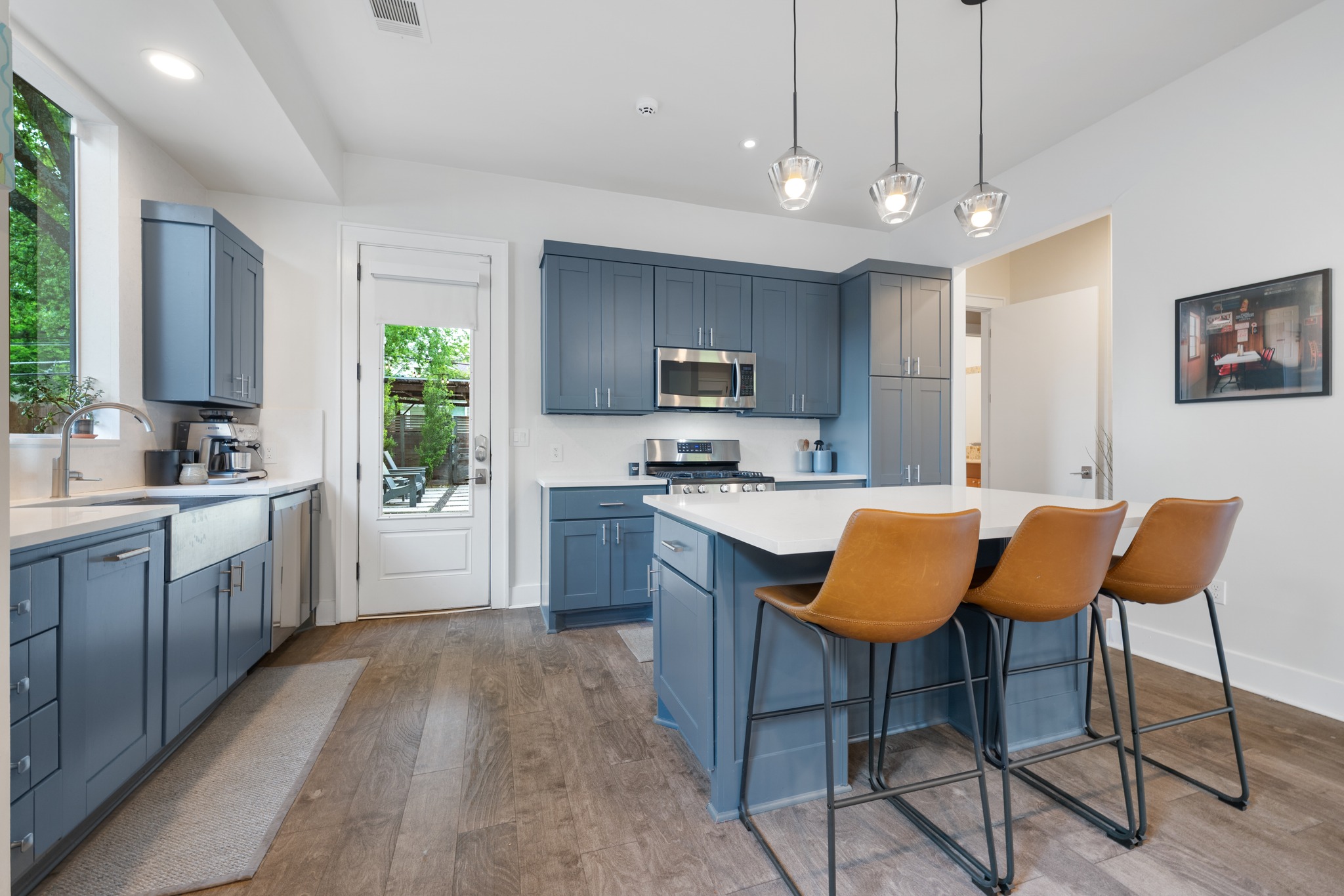 4904 Duval Street, Unit A Austin, TX 78751 - Photo 13 of 39 a kitchen with stainless steel appliances granite countertop a stove top oven a sink dishwasher a dining table and chairs with wooden floor