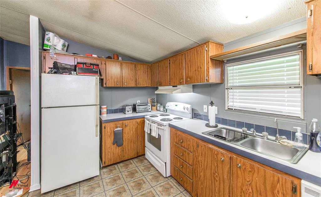 891 Pilgrim Rest Road Doyline, LA 71023 - Photo 21 of 37 a kitchen with stainless steel appliances granite countertop a refrigerator sink and wooden cabinets