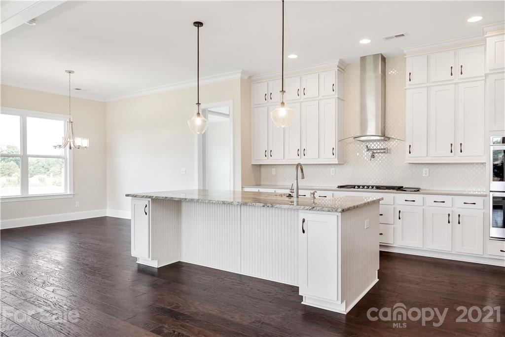 318 Grassy Rdg Court Clover, SC 29710 - Photo 6 of 31 a kitchen with stainless steel appliances granite countertop a sink a stove a refrigerator and white cabinets with wooden floor