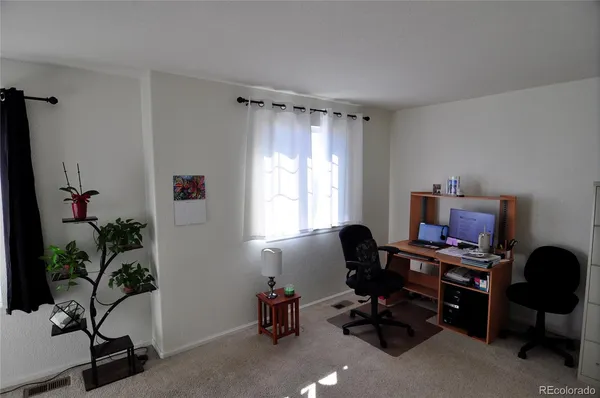 a view of a workspace with furniture and a window
