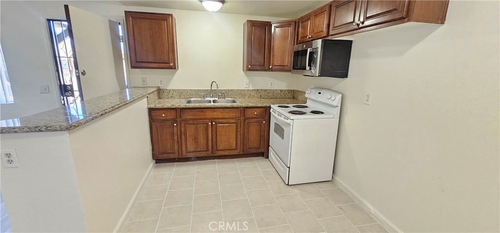 4211 Mountain Drive, Unit 2 San Bernardino, CA 92407 - Photo 4 of 11 a kitchen with stainless steel appliances granite countertop a refrigerator and a stove top oven