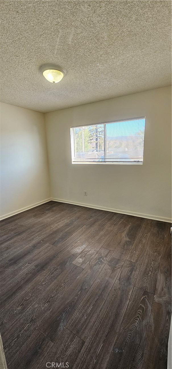 4211 Mountain Drive, Unit 2 San Bernardino, CA 92407 - Photo 9 of 11 an empty room with wooden floor and windows
