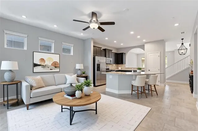 a living room with furniture kitchen view and a chandelier