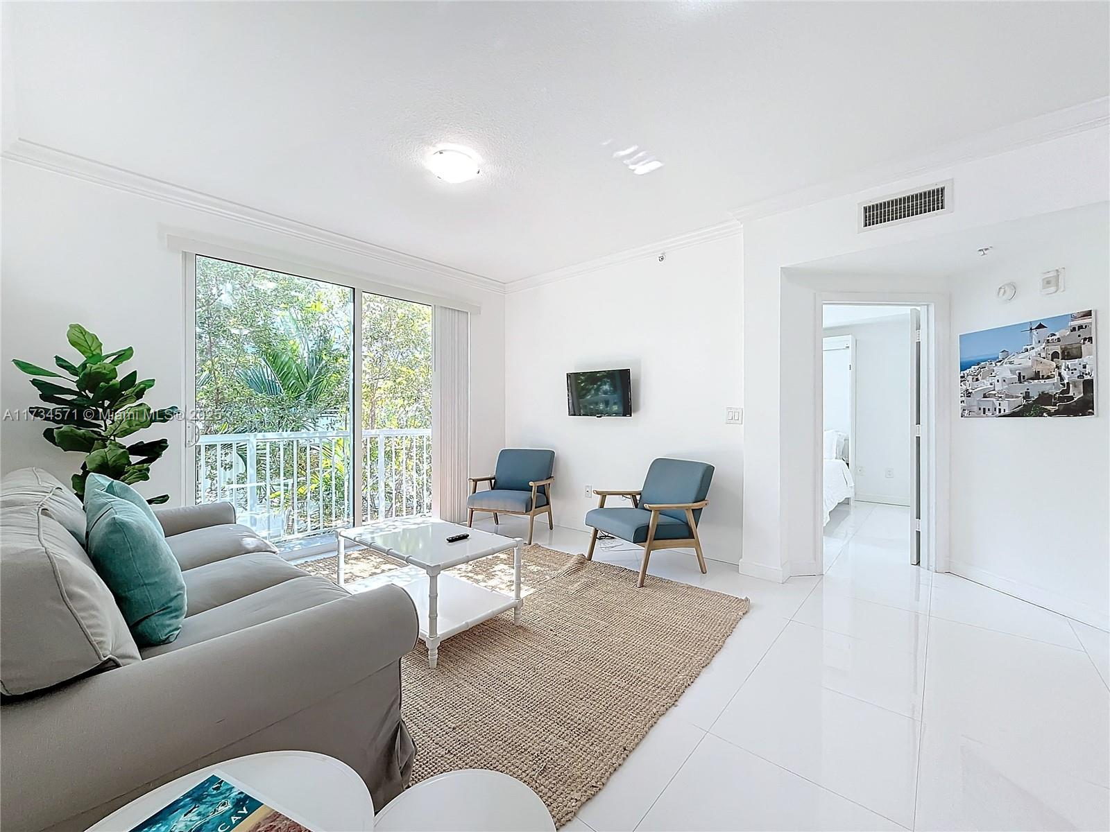9172 Collins Avenue, Unit 414 Surfside, FL 33154 - Photo 2 of 23 a living room with furniture and a large window