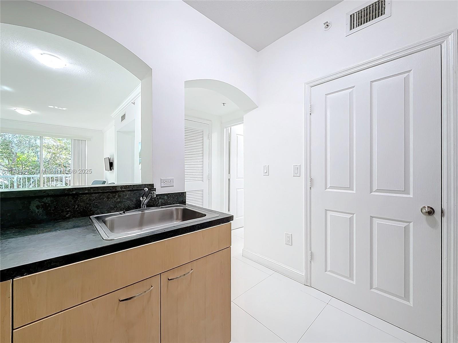 9172 Collins Avenue, Unit 414 Surfside, FL 33154 - Photo 5 of 23 a bathroom with a sink and a mirror
