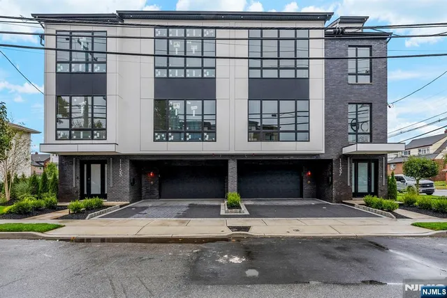a front view of a building with a garden and plants