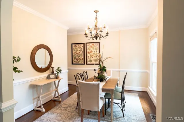 a dining room with furniture a chandelier and wooden floor