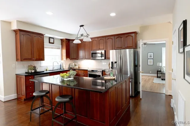a kitchen with stainless steel appliances a stove refrigerator sink and microwave