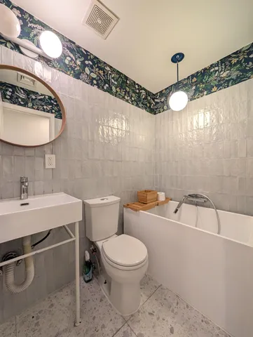 a bathroom with a sink a toilet and a mirror