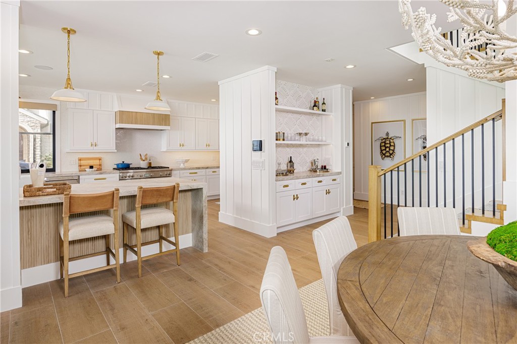6110 West Oceanfront Newport Beach, CA 92663 - Photo 7 of 33 a open kitchen with stainless steel appliances kitchen island granite countertop a table chairs and a living room view