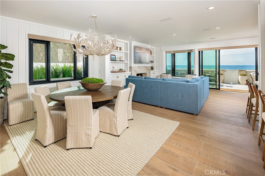 6110 West Oceanfront Newport Beach, CA 92663 - Photo 9 of 33 a living room with furniture a large window and a dining table