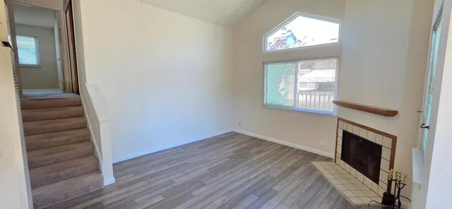 an empty room with windows and fireplace