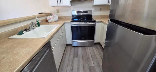 a kitchen with a sink a stove and cabinets