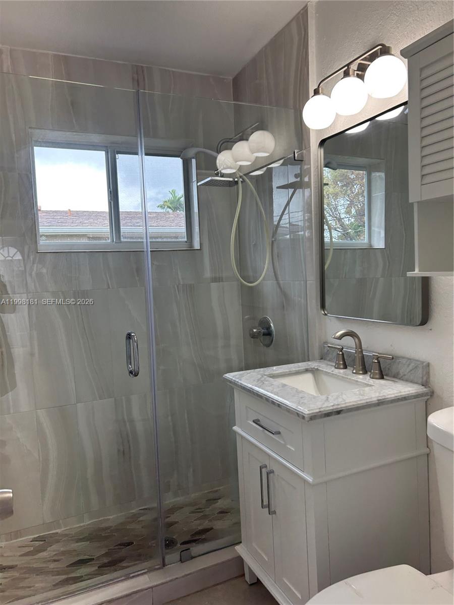 2804 Southwest 35th Avenue, Unit 2804 Miami, FL 33133 - Photo 13 of 22 a bathroom with a sink a mirror and a shower