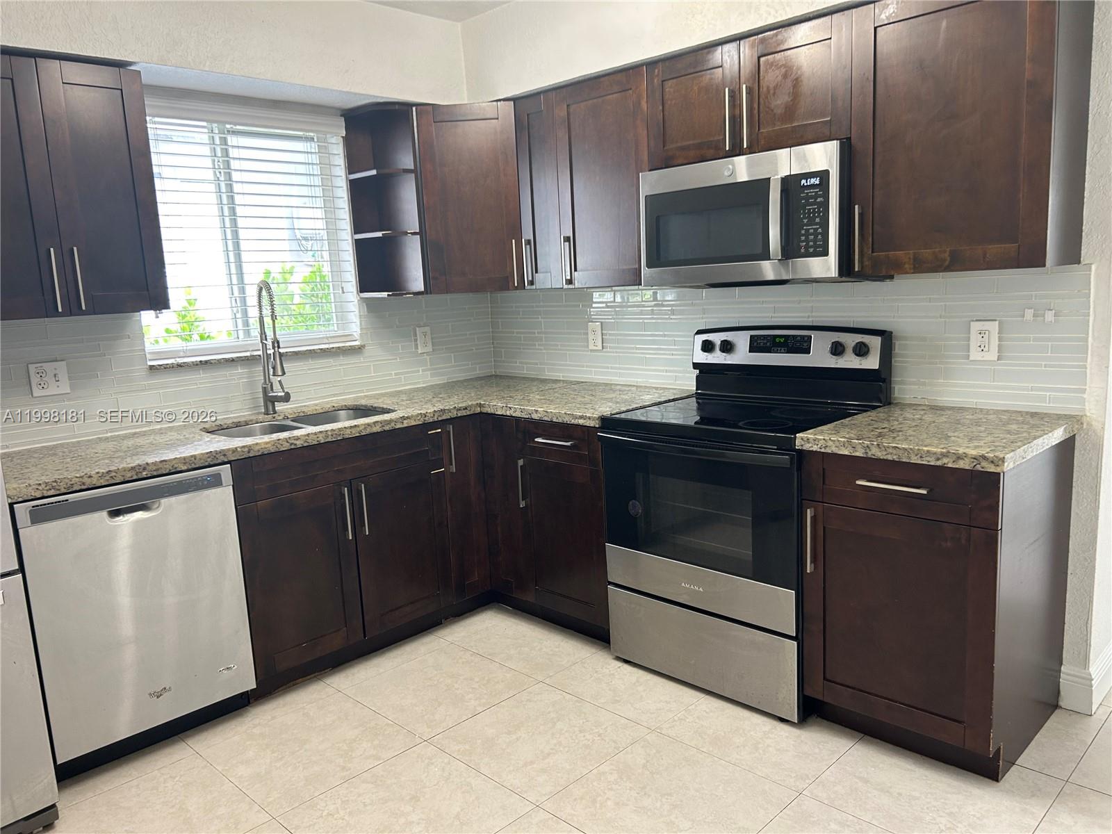 2804 Southwest 35th Avenue, Unit 2804 Miami, FL 33133 - Photo 7 of 22 a kitchen with a sink stove and microwave