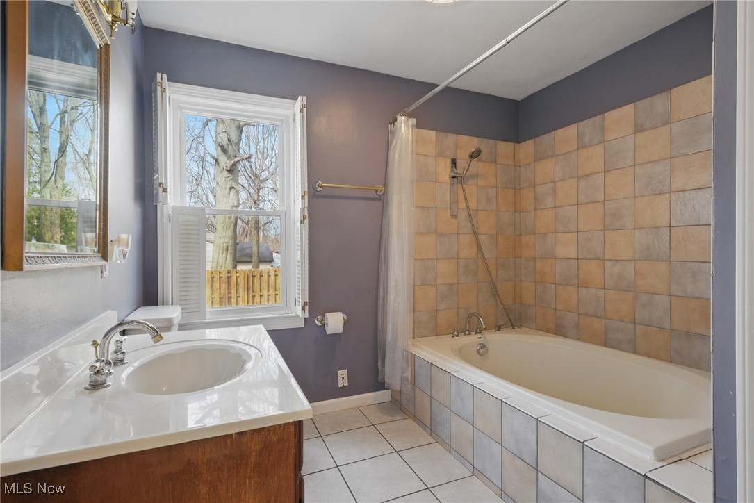 28575 White Road Wickliffe, OH 44092 - Photo 15 of 49 Full bathroom featuring tiled shower / bath, tile patterned floors, vanity, and baseboards