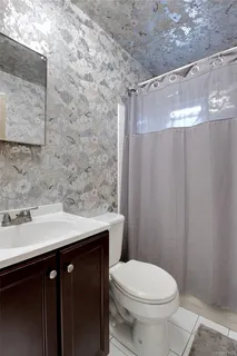 a bathroom with a sink a toilet and shower