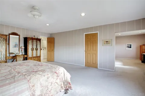 a spacious bedroom with a large bed and a chandelier