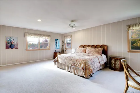 a spacious bedroom with a bed and wooden floor