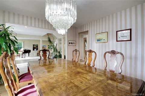 a dining room with furniture a chandelier and window