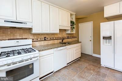 6112 Mt Ridge Road Baltimore, MD 21228 - Photo 8 of 30 a kitchen with granite countertop white cabinets and white appliances