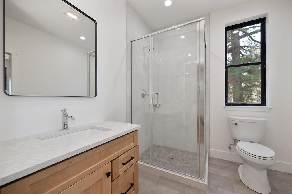 5205 Rooster Lane Somerset, CA 95684 - Photo 18 of 98 a bathroom with a toilet a sink and glass door
