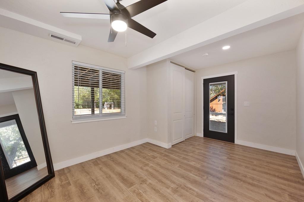 5205 Rooster Lane Somerset, CA 95684 - Photo 39 of 98 a view of an empty room with wooden floor and a window