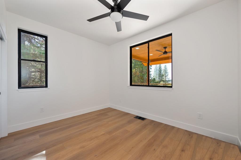 5205 Rooster Lane Somerset, CA 95684 - Photo 55 of 98 a view of an empty room with a window and wooden floor