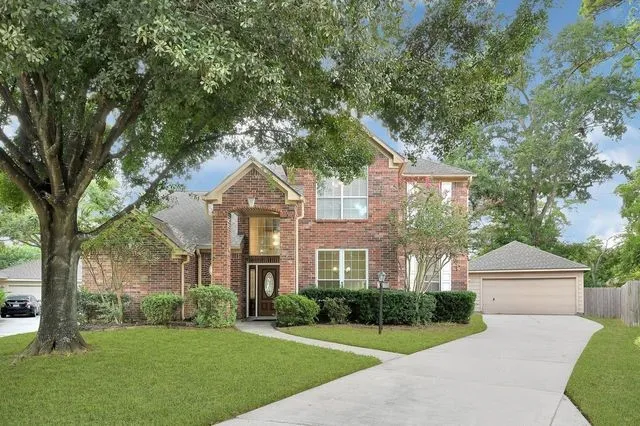a front view of a house with a yard and trees