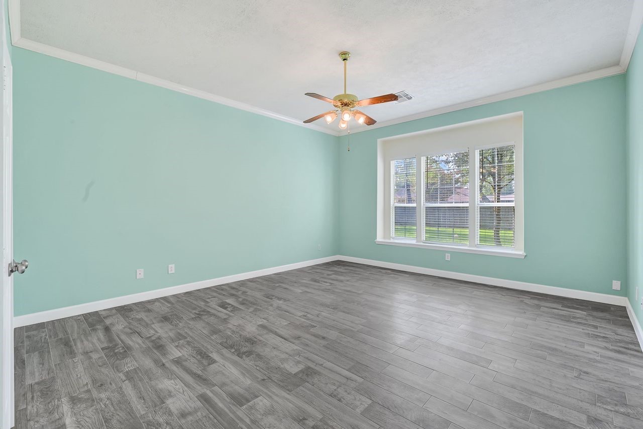 19126 South Rim Trail Spring, TX 77388 - Photo 13 of 21 an empty room with wooden floor chandelier fan and windows