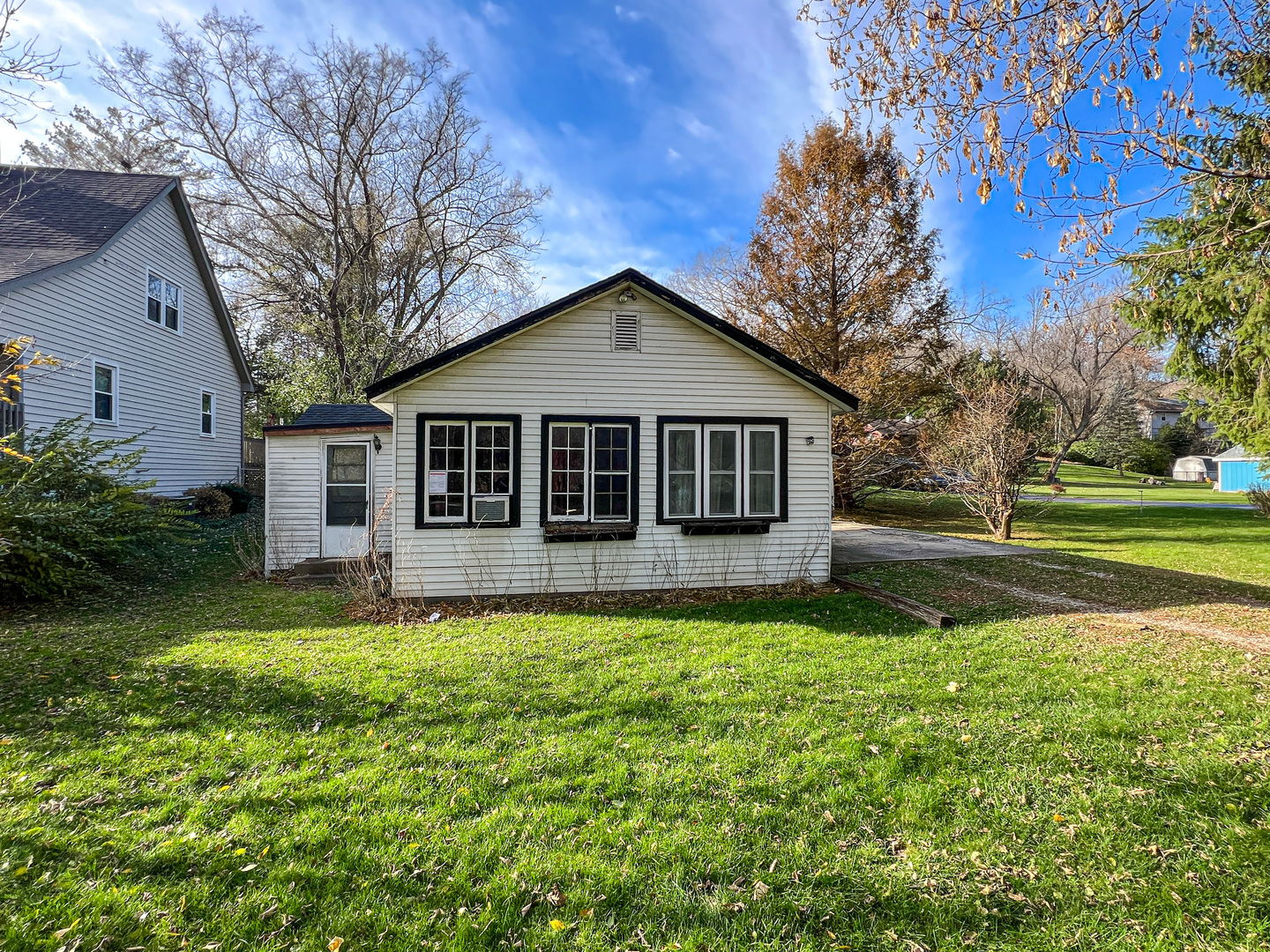 a view of a house with a big yard and large trees