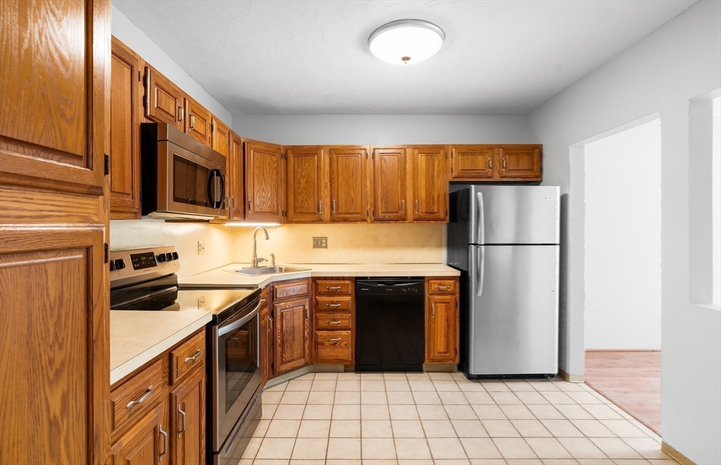 200 Ridgefield Circle, Unit C Clinton, MA 01510 - Photo 8 of 35 a kitchen with stainless steel appliances granite countertop a refrigerator stove top oven and sink