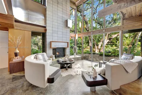 a living room with furniture a fireplace and a large window