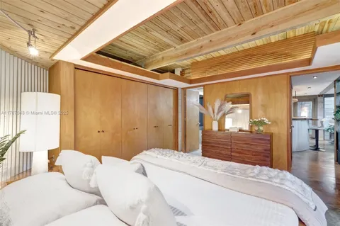 a spacious bedroom with a bed and wooden floor