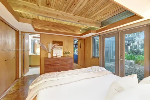 a bedroom with furniture and a large window