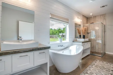 a bathroom with a tub sink and mirror