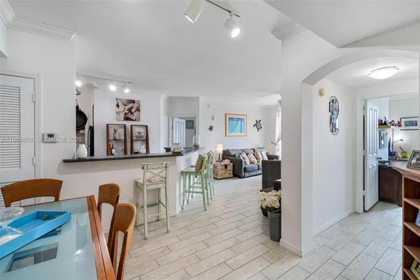 a living room with furniture a dining table and a refrigerator