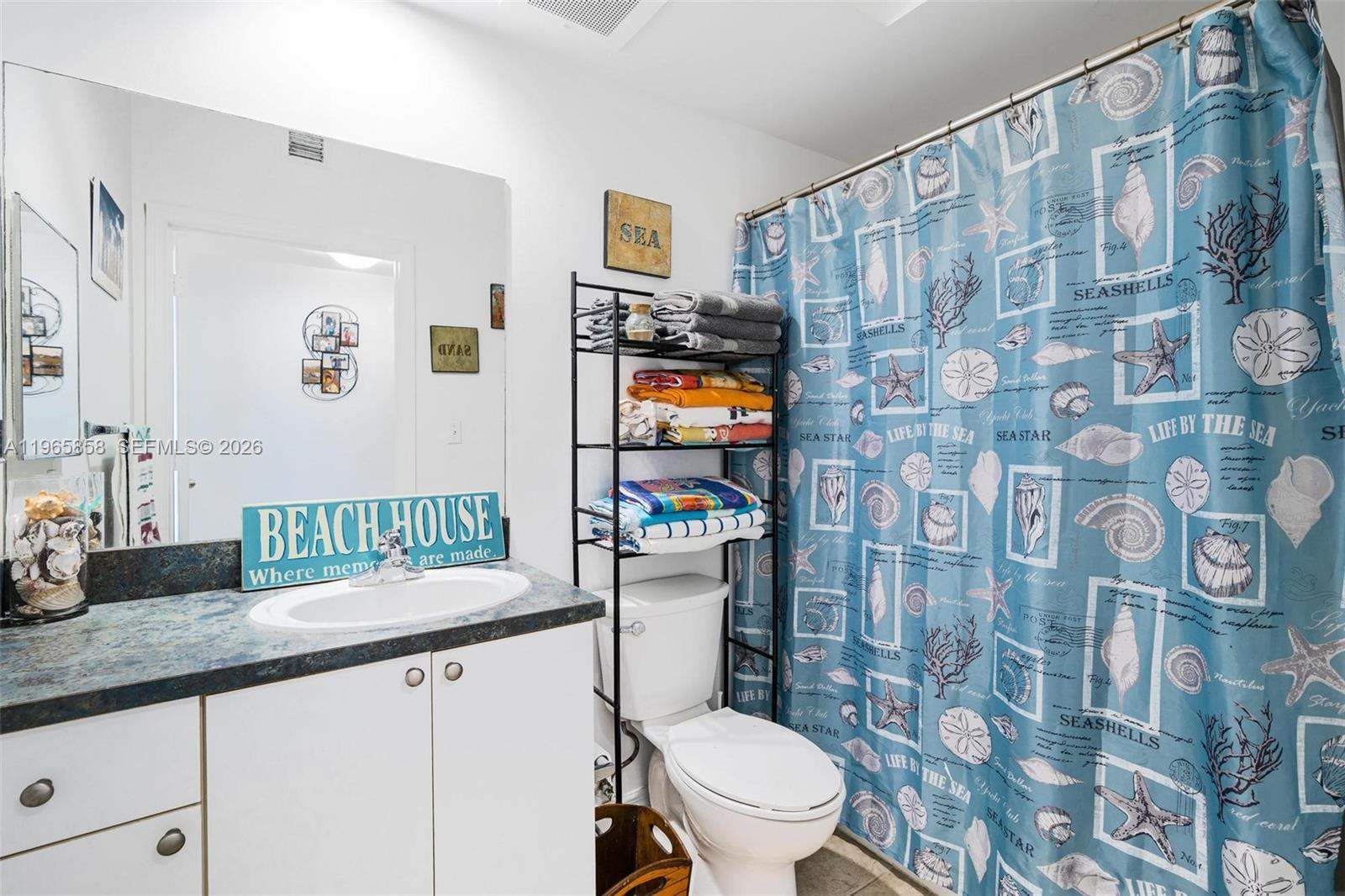 9172 Collins Avenue, Unit 210 Surfside, FL 33154 - Photo 23 of 41 a bathroom with a granite countertop sink mirror vanity and toilet