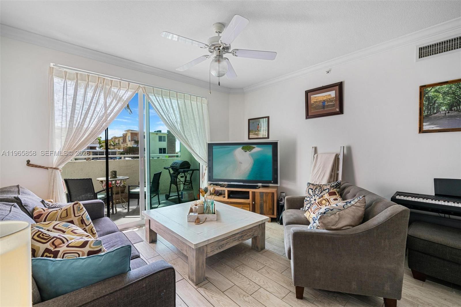 9172 Collins Avenue, Unit 210 Surfside, FL 33154 - Photo 3 of 41 a living room with furniture a flat screen tv and a large window
