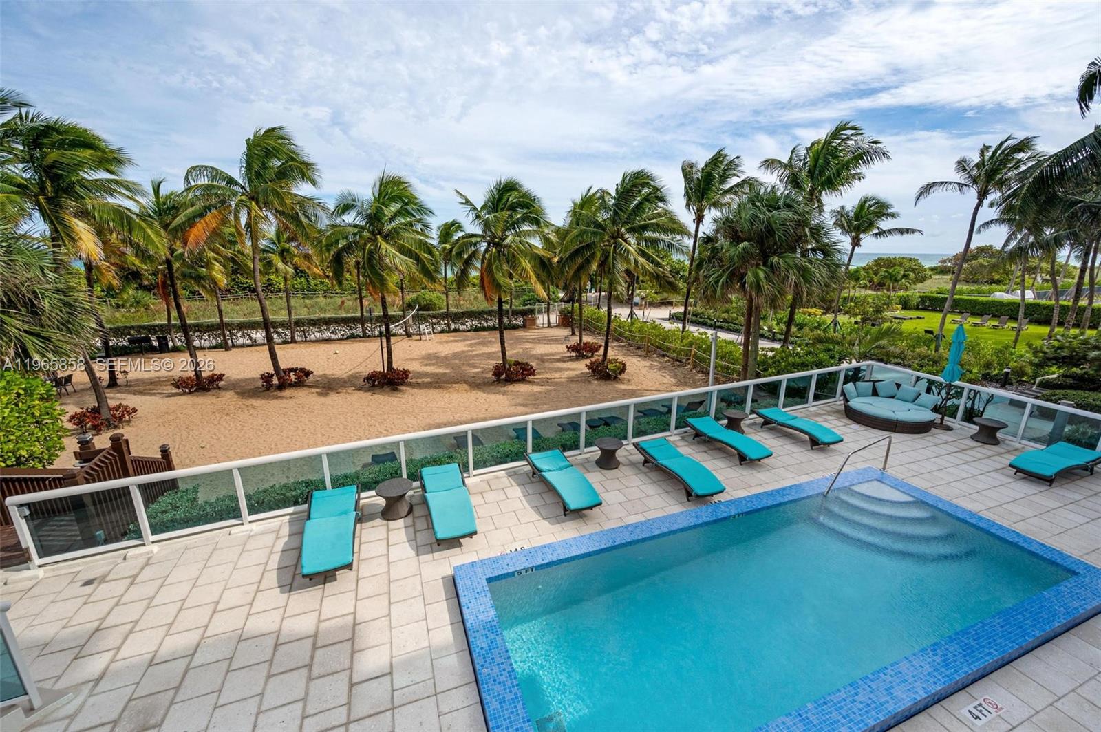 9172 Collins Avenue, Unit 210 Surfside, FL 33154 - Photo 37 of 41 a view of a swimming pool with lounge chairs