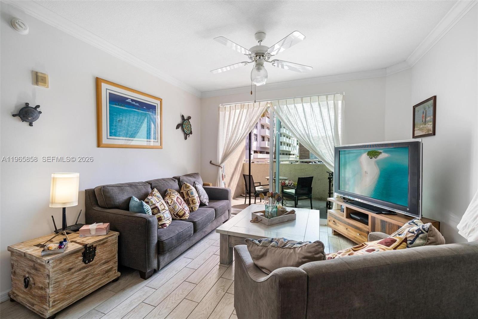 9172 Collins Avenue, Unit 210 Surfside, FL 33154 - Photo 7 of 41 a living room with furniture and a flat screen tv