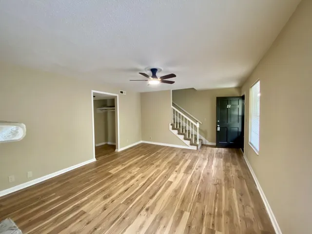 a view of a hallway with wooden floor and a chandelier