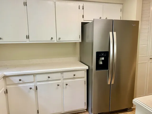 a kitchen with stainless steel appliances white cabinets and a refrigerator