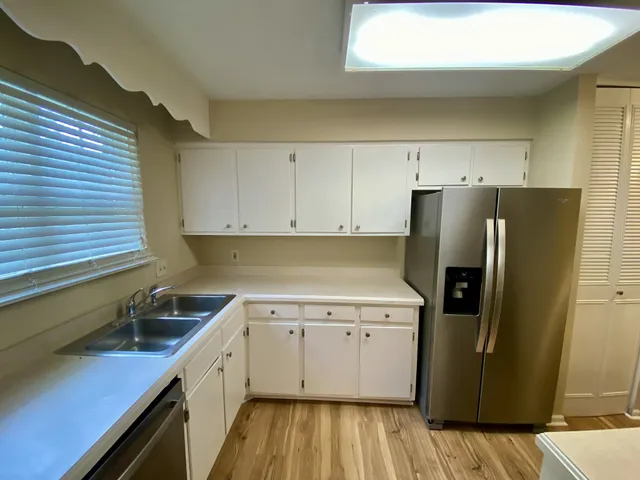 a kitchen with a sink a refrigerator and cabinets