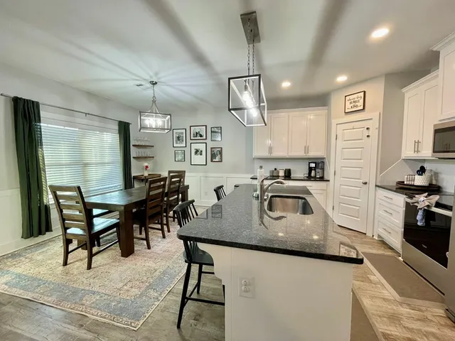 a kitchen with stainless steel appliances granite countertop a stove top oven a refrigerator a sink and dishwasher