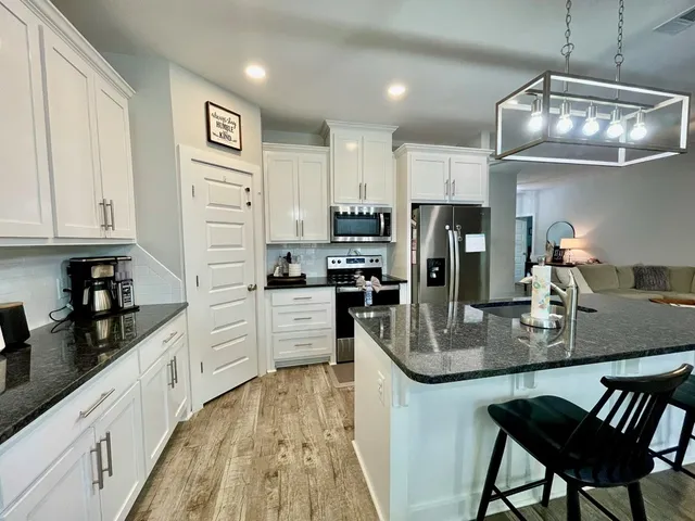 a kitchen with granite countertop a refrigerator stove top oven and sink