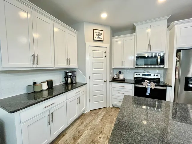 a kitchen with stainless steel appliances a stove a refrigerator and a sink