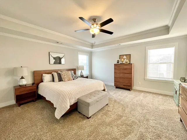 a spacious bedroom with a bed and a chandelier