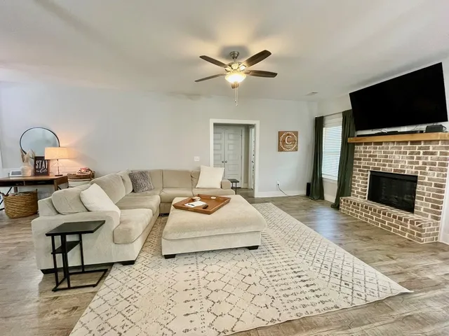 a kitchen with stainless steel appliances granite countertop a stove top oven a refrigerator a sink and chairs